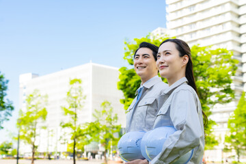 新緑の街に立つ男女エンジニアのグループ