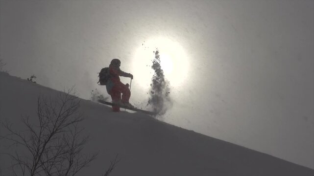 Skieur jetant de la neige avec ces skis bras ouvert