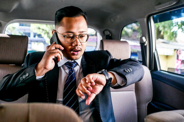 Businessman On Phone Call Checking Time, Managing Tight Schedule Inside Car