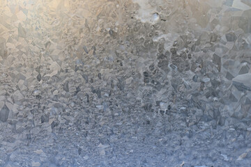 ice pattern on winter glass, abstract background on a cold sunny day