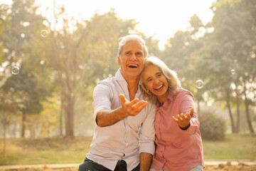 Fototapeta premium Seniors Enjoying Time Together And Playing With Bubbles