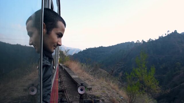 A man enjoys a ride on the toy train running from Kalka to Shimla (Simla), the capital of Himachal Pradesh in North India, located in the northern Himalayas. It is part of the Indian Mountain Railways