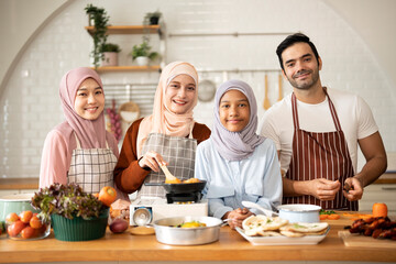 Portrait Of happy Muslim family cooking in modern Kitchen