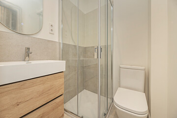 Modern bathroom with a light wood vanity unit and handleless drawers, creating clean lines and a built-in look