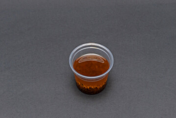 Shot   with spicy barbecue sauce, showing its thick consistency and the characteristic sticky sheen when poured