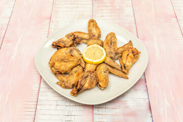 Crispy fried chicken wings with lemon pepper sauce, sprinkled with lemon zest