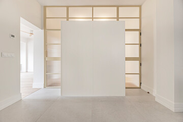 Modular white wardrobes with white metal frame pivot doors and translucent glass for light distribution