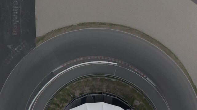 Zandvoort, Netherlands - August 18, 2025: Aerial Drone Footage Zooming Out Above First Corner of Formula 1 Circuit
