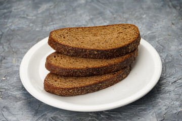 three slices of brown bread in a white plate on a background