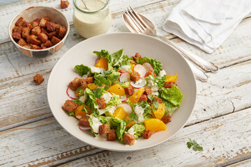 Caesar salad with orange and radishes