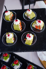 Unique green sushi rolls served on a black platter at an elegant event in Japan, showcasing artistic culinary presentation and vibrant colors