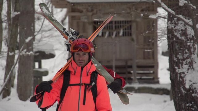 Skieur marchant devant temple japonais