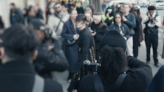 Paparazzi taking photos of a celebrity on the street