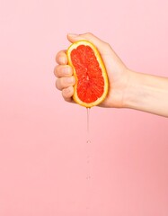 Hand squeezing grapefruit slice (1)