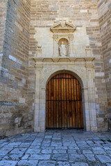 Main entrance of Santa Eulalia Church in Torquemada, Palencia with stone sculpture