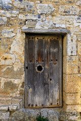Old wooden door on stone wall in the village of Villamediana in Palencia