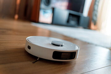 White robotic vacuum cleaner on wooden floor