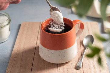 Pouring sweetener powder in cup of coffee. Sugar alternative, food and nutrition