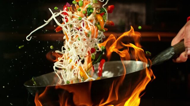Super Slow Motion of Flying Asian Meal with Meat and Vegetable. Filmed on High Speed Cinema Camera, 1000 fps. Camera in Motion. Blur Kitchen Interior on Background.