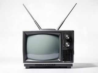 A realistic front-on photograph of a vintage television with a dark grey plastic casing and a pair of long, retractable metal 'rabbit ear' antennas extended from the top.