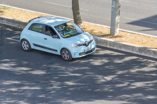 Light blue renault twingo parking on roadside in summer sunlight