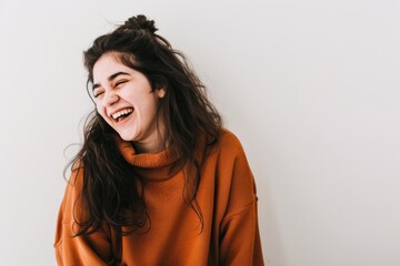 Fototapeta premium Woman laughing in orange sweater