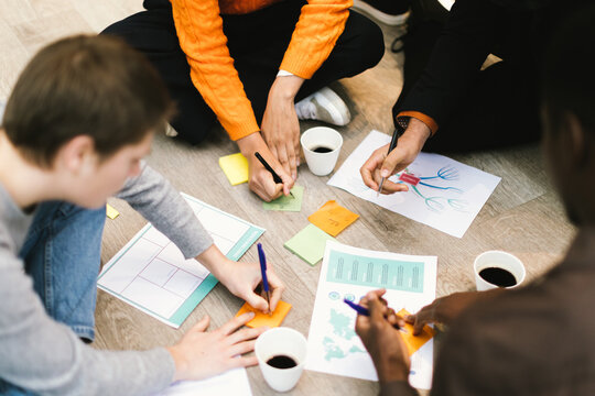 Marketing team brainstorming and taking notes during meeting