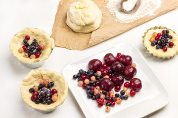 Frozen berries in plate. Dough and berries in baking cup.