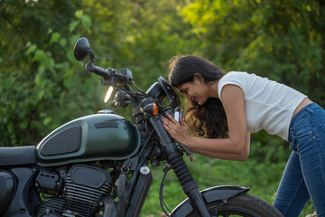 Obraz premium Strong independent Indian woman biker: beautiful girl, stylish rider, motorcycle adventure, elegant jacket, confident posture, powerful machine, free spirit, road journey, fearless attitude.