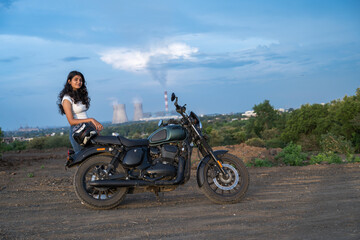 Obraz premium Strong independent Indian woman biker: beautiful girl, stylish rider, motorcycle adventure, elegant jacket, confident posture, powerful machine, free spirit, road journey, fearless attitude.