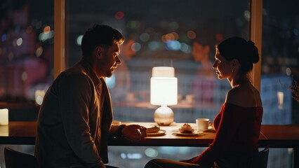 Romantic spouses talking night cafeteria blurred view. Romantic couple dinner