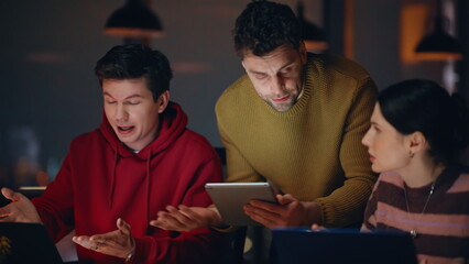 Worried colleagues looking solutions at dark workplace closeup. Group coworkers