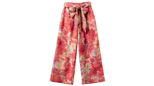 Close up view of a woman wearing brightly colored pink and orange floral print pants highlighting the intricate botanical pattern and the texture of the fabric in a stylish outfit.