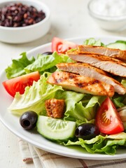 Fresh chicken salad with lettuce, tomato, cucumber, and olives, a healthy and delicious meal