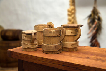  wooden mugs with lids on a table in a Ukrainian tavern