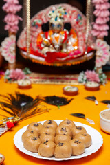 Traditional Peda  Offering on Plate with Krishna Idol in Background