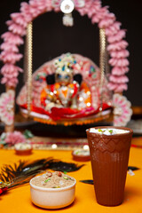 Hindu Festival Offering with Krishna Statue and Traditional Sweets