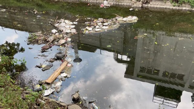 Polluted River Filled with Trash Near Industrial Factory