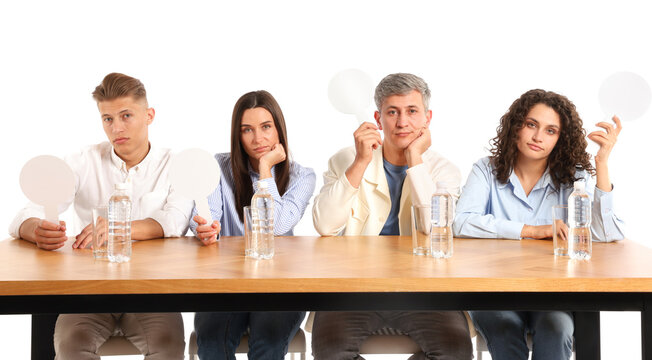 Panel of judges with blank score signs at table on white background