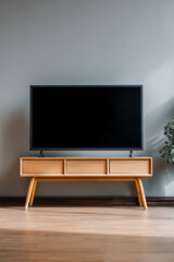 a flat screen tv with a blank black screen stands on a light wooden stand
