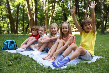 Fototapeta premium Cute little kids on green grass in park