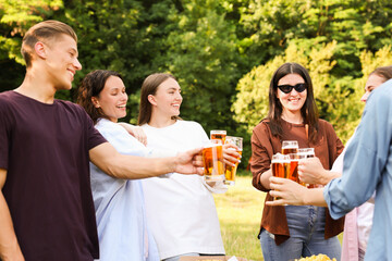 Group of happy friends clinking glasses of beer outdoors