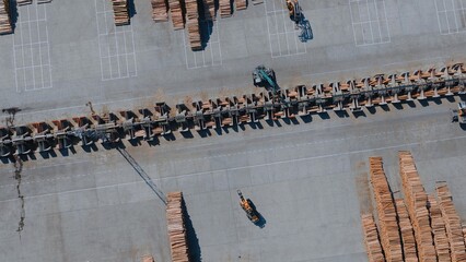 Forklifts handling lumber at large lumber processing mill with conveyor system