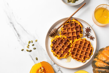 Delicious pumpkin waffles with honey and star anise on marble background. Autumn recipes. Copy space