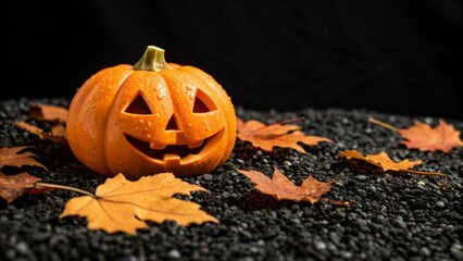Festive halloween pumpkin jack o lantern with carved face on dark background with autumn leaves for seasonal celebration