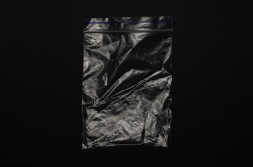 Transparent empty ziplock bag isolated on black background, clear plastic pouch with resealable...