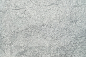 Wrinkled white package paper texture, isolated on background. Rough creased surface ideal for packaging, wrapping, crafts, scrapbooking, design, and artistic projects.