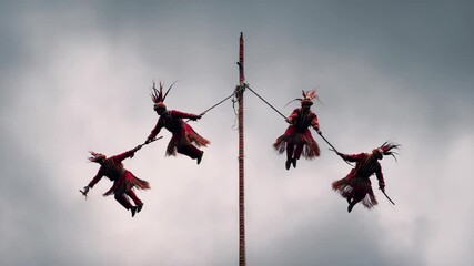 Traditional Voladores Aerial Ceremony with Indigenous Dancers Spinning from Tall Ritual Pole in Sky