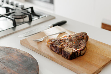 Cooked T-bone steak resting on wooden board