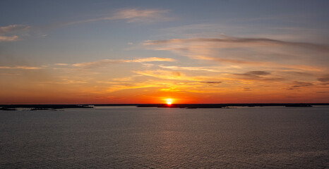 Bright sunset over the sea, horizon, and islands on the horizon.